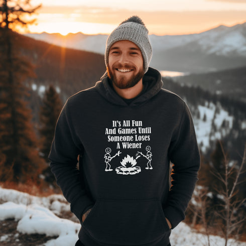 Our Camping hoodie features two adorable stick figure people roasting wieners over a cozy campfire. And with the hilarious slogan "It's All Fun & Games Until Someone Loses A Wiener," you'll be the life of the party at any camping trip!
